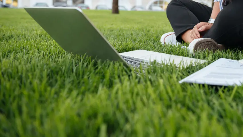 Girl on grass with computer