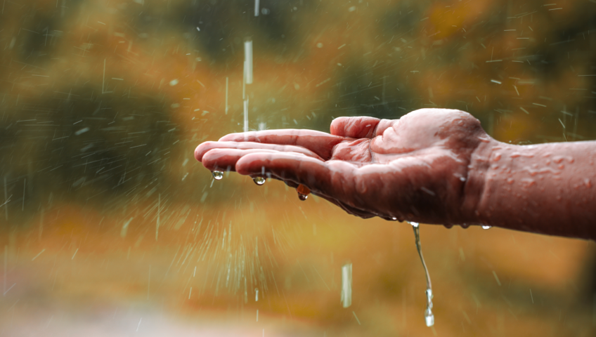 Raindrop hitting man's outstretched palm