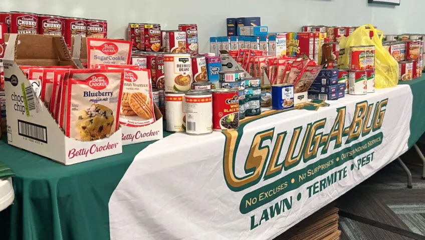 A Slug-A-Bug table piled with donated food items